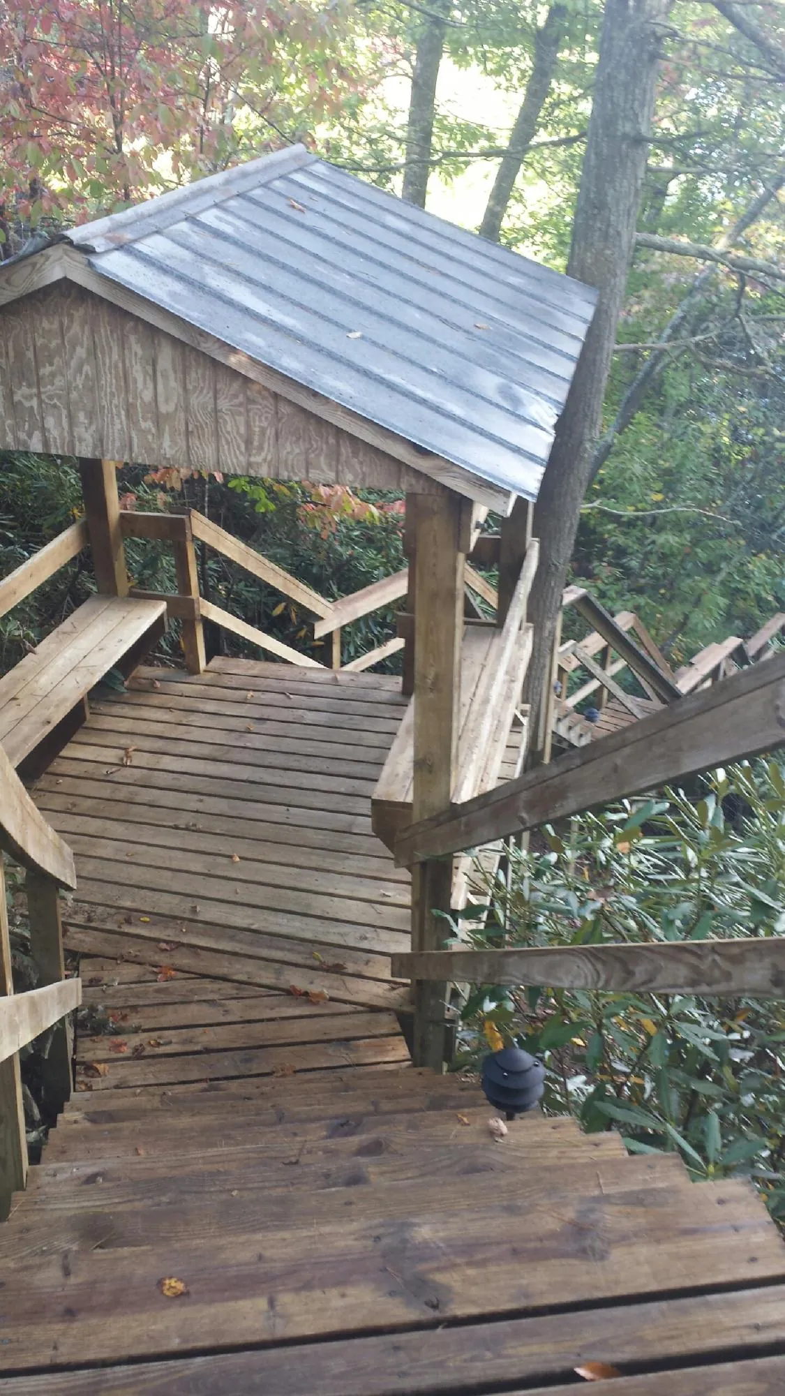 Metal roofed shelter over wooden steps on a wooded walkway — Skylight Repair & Installation work by our crew in Sprague