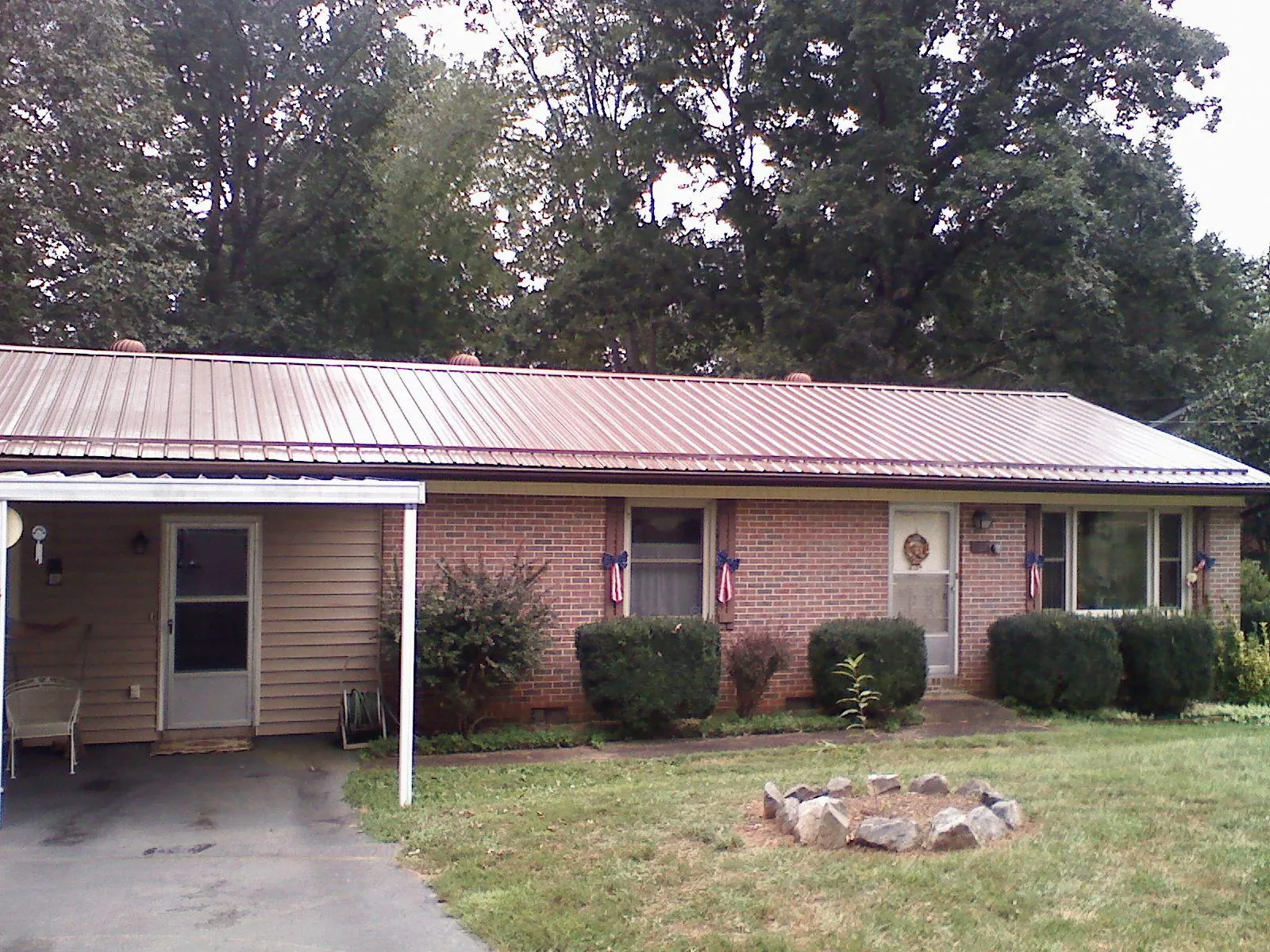 Bronze metal roof and carport on a brick ranch home — Roof Repair work by our crew in Sprague